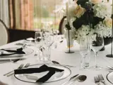 Round table set up in Boclair House Grand Ballroom with white linens, floral centerpieces, and elegant glassware.