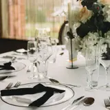 Round table set up in Boclair House Grand Ballroom with white linens, floral centerpieces, and elegant glassware.