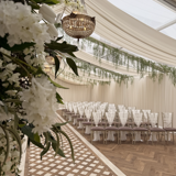 A beautifully arranged wedding ceremony set up the Pavilion at Cornhill Castle in Biggar, Scotland,  featuring floral decorations and elegant seating for guests.