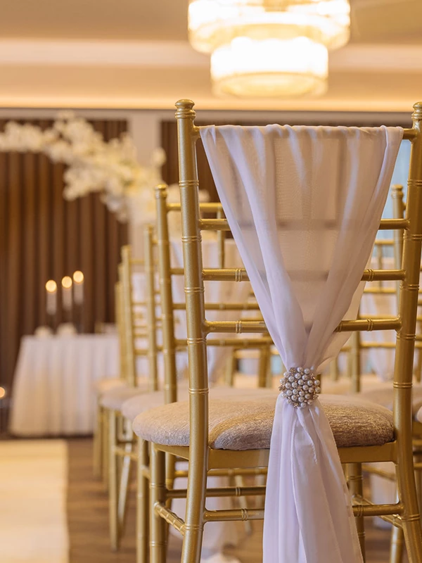Ceremony aisle setup at Redhurst Hotel wedding venue Glasgow featuring elegant chairs and floral centrepieces.