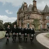 Groom and Groomsmen walking away from castle