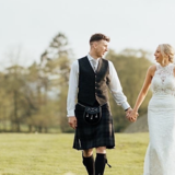 Couple holding hands walking in the fields
