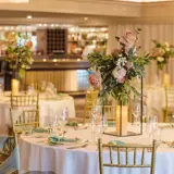 Wedding reception meal set up in the Grand Ballroom with floral centrepieces