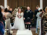 Newlyweds walking down the aisle in the Grand Ballroom at Redhurst Hotel, Glasgow