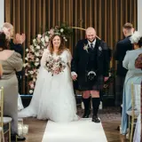 Newlyweds walking down the aisle in the Grand Ballroom at Redhurst Hotel, Glasgow