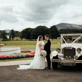 Couple just married in front of a wedding car