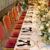 wedding party dinner arrangements with neat plates and chairs