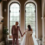 Couple posing at ornate windows in hallway