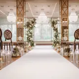 Interior view of the New Grand Ballroom at Boclair House, Glasgow, featuring luxury wedding decor, mirrored pillars, and a sparkling crystal chandelier