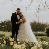 Couple sharing a moment in field after wedding
