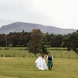 Couple walking in field after their wedding