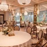 The Grand Ballroom at Boclair House Hotel set for a wedding meal, featuring rows of formal dining tables and opulent overhead chandelier lighting in a luxury Glasgow setting.