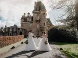 Same sex couple holding hands outside Cornhill Castle