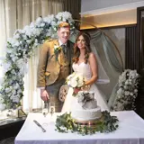 Couple standing infront of a cake