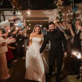 Couple walking through arch of sparklers