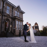 Couple kissing outside of Lynnhurst at sunset