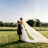Couple walking on the grounds with sun setting on the background