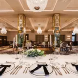 Wedding ceremony space at Boclair House Hotel, showcasing the New Ballroom's grand architecture, ornate gold ceiling, and white floral aisle decor for a luxury Glasgow wedding.