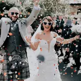 Couple celebrating with sunglasses and confetti