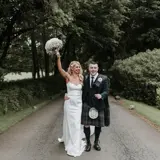 Happy couple walking up the driveway hand in hand