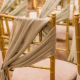 Wedding ceremony gold and sage seat covers in the Grand Ballroom
