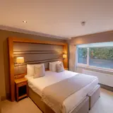 Luxury double room at Bowfield Hotel & Spa, the best spa hotel near Glasgow, featuring a large bed, warm lighting and countryside views.