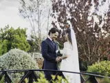 A couple during their outdoor wedding ceremony surrounded by greenery in the background