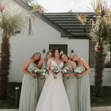 Bridal party around bride in garden