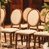 Intimate wedding ceremony setup in the Grand Ballroom at Boclair House, Glasgow, featuring elegant floral pillars and classic oval-back chairs 