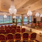 wedding ceremony hall with chandeliers filled with ornate chairs