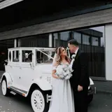 Couple standing infront of wedding car