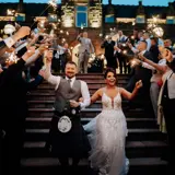 Couple walking down the stairs through sparklers at Boclair House Hotel