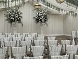 A beautifully arranged wedding ceremony set up inside the Pavilion at Cornhill Castle in Biggar, Scotland,  featuring rows of elegant seating and  floral decorations.