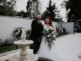 Couple standing smiling behind fountain at The Garden House