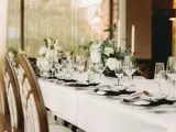 Table layout at Boclair House Hotel Grand Ballroom, Glasgow, featuring luxury tableware, and white floral centerpieces for a wedding meal.