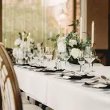 Table layout at Boclair House Hotel Grand Ballroom, Glasgow, featuring luxury tableware, and white floral centerpieces for a wedding meal.