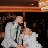Bride and groom kissing next to cake
