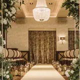Luxury wedding ceremony setup in the Grand Ballroom at Boclair House, Glasgow, featuring a white aisle runner, mirrored floral pillars, and elegant ceremony seating