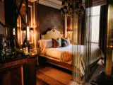 A Honeymoon Suite at Boclair House in Glasgow featuring a chandelier and elegant gold accents throughout the decor
