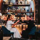 Couple sharing a drink at the bar after getting married