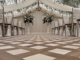 An elegant wedding ceremony set up at the Pavilion at Cornhill Castle in Biggar, Scotland, featuring wooden flooring and neatly arranged white chairs for attendees.