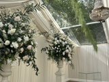 Beautifully decorated wedding reception area at the Pavilion at Cornhill Castle in Biggar, Scotland, featuring white flowers and an elegant chandelier hanging from the ceiling