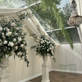 Beautifully decorated wedding reception area at the Pavilion at Cornhill Castle in Biggar, Scotland, featuring white flowers and an elegant chandelier hanging from the ceiling
