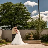 Bride and groom in outdoor garden next to water fountain at Redhurst Hotel, Giffnock