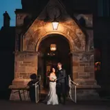Couple posing at night at the front entrance of the castle