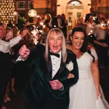 Same sex couple walking under sparklers