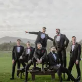 Groom and groomsmen posing for picture in field at Conrhill Castle