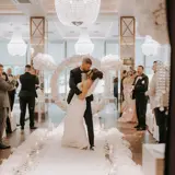 Couple kissing half way up the aisle