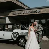 Couple kissing infront of Redhurst next to a wedding car